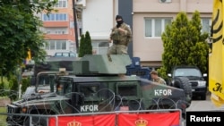 FILE - U.S. members of the NATO-led Kosovo Force (KFOR) stand guard outside municipal offices in Leposavic, Kosovo, June 2, 2023.