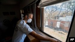 FILE - Daniel Skousen vacuums his home, damaged by August's wildfire, on Nov. 3, 2023, in Lahaina, Hawaii. 