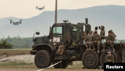 FILE - U.S. troops observe as V-22 Osprey aircraft are flown during the annual joint military exercises between U.S. and Philippine troops at a naval base in San Antonio, Zambales province, Philippines, April 26, 2023.