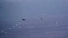 In this image from video released by the U.S. Air Force, Russian military SU-34 and SU-35 aircraft release flares in the flight path of a U.S. Air Force MQ-9 Reaper drone, lower left, July 6, 2023, over Syria. 