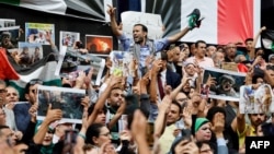 Wamisri wakipiga kelele huku wakipeperusha bendera za taifa wakati wa maandamano nje ya Baraza la Waandishi wa Habari huko Cairo Oktoba 18, 2023. Picha na Khaled DESOUKI / AFP.