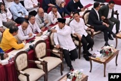 Presiden terpilih Prabowo Subianto berbincang dengan sejumlah politisi dari koalisi partai yang mendukungnya saat acara penetapan hasil pilpres 2024 di Komisi Pemilihan Umum (KPU) di Jakarta, 24 April 2024. (Foto: Adek Berry/AFP)
