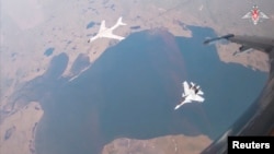 俄罗斯国防部2024年7月24日发布照片显示，中国空军一架 H-6K 轰炸机与一架俄军Su-30CM 喷气式战机在美国阿拉斯加州附近上空联合巡逻.