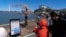 With the Washington Monument and Jefferson Memorial in the background, visitors take photographs of Stumpy, the popular cherry tree at the Tidal Basin as cherry trees enter peak bloom this week in Washington, March 24, 2024. 