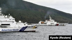 中国海警船进入有争议的尖阁列岛（中国称钓鱼岛）海域，在日本海岸警卫队巡逻舰旁驶过。（2024年4月27日）