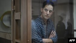 U.S. journalist Evan Gershkovich, arrested on espionage charges, stands inside a defendants' cage before a hearing to consider an appeal on his arrest at the Moscow City Court in Moscow, April 18, 2023