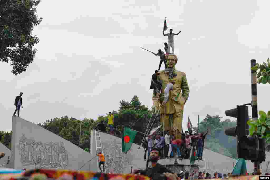 People vandalize the statue of Sheikh Mujibur Rahman at Bijoy Sarani area, the 'Father of the Nation,' as they celebrate the resignation of the Prime Minister Sheikh Hasina in Dhaka, Aug. 5, 2024.