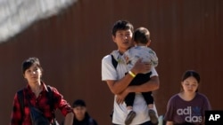 FILE - Migrants walk after crossing the U.S.-Mexico border near Jacumba, California, Oct. 24, 2023. China has resumed cooperating with the U.S. to repatriate Chinese migrants illegally stranded in the U.S., The Associated Press reported Thursday.   