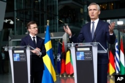 NATO Secretary General Jens Stoltenberg, right, and Sweden's Prime Minister Ulf Kristersson address a media conference prior to a flag raising ceremony to mark the accession of Sweden to NATO at NATO headquarters in Brussels, March 11, 2024.