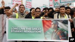 Houthi backers shout slogans during a rally against the U.S.-led strikes against Yemen and in support of Palestinians in the Gaza Strip, in Sanaa, Yemen, April 26, 2024. The Arabic reads, "Boycott American and Israeli goods, death to America and Israel."