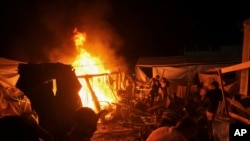 Palestinians react to fire from an Israeli strike that hit a tent area in the courtyard of Al Aqsa Martyrs hospital in Deir al Balah, Gaza Strip, Aug. 4, 2024.