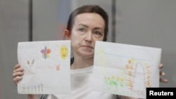 American-Russian journalist for Radio Free Europe/Radio Liberty (RFE/RL) Alsu Kurmasheva, holds drawings by her supporters as she attends a court hearing in Kazan, Russia, May 31, 2024. 