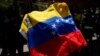 Un manifestante sostiene una bandera venezolana, mientras trabajadores sindicales, miembros de partidos políticos de oposición y otros participan en una protesta contra el gobierno venezolano, durante el día de Mayo, en Caracas, Venezuela, el 1 de mayo de 2023.