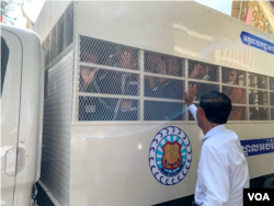 លោក រ៉ុង ឈុន អនុប្រធានគណបក្សភ្លើងទៀន លើកដៃលា អតីតសកម្មជនគណបក្សសង្គ្រោះជាតិ នៅតុលាការកំពូល រាជធានីភ្នំពេញ កាលពីថ្ងៃទី១៦ ខែមីនា ឆ្នាំ២០២៣។ (លាស់ លីបលីប/វីអូអេ)