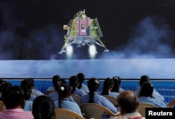 Orang-orang menonton siaran langsung pendaratan pesawat ruang angkasa Chandrayaan-3 di Bulan, di dalam auditorium Gujarat Science City di Ahmedabad, India, 23 Agustus 2023. (Foto: REUTERS/Amit Dave)