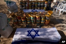 The coffins of Roee Munder who was killed on Oct. 7, 2023, and is being reburied, and his father, Avraham Munder, who was killed in Hamas captivity and recovered by the Israeli military in Gaza, lie together at the Kibbutz Nir Oz, Israel, Aug. 21, 2024.