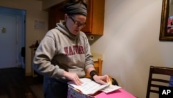 Samantha Richards looks over her Medicaid papers in Bloomington, Indiana, June 9, 2023. Richards has been on Medicaid throughout her life and works two part-time jobs as a custodian.