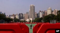 A worker sprays water on Victoria Park, as the government closed parts of the traditional venue of the city's annual Tiananmen crackdown vigil for "maintenance works," in Hong Kong, May 30, 2023.