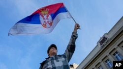Ilustracija - Učesnik protesta "Srbija protiv nasilja" maše zastavom Srbije (AP Photo/Darko Vojinovic)