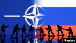 Foto ilustrasi yang menggambarkan figur tentara ditampilkan di depan bendera Rusia dan NATO. Foto diambil pada 13 Februari 2022. (Foto: Reuters/Dado Ruvic)
