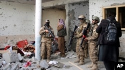 FILE - Taliban fighters inspect a house after a gunbattle erupted between Taliban and Islamic State group fighters, during a Taliban raid of a suspected hideout of IS militants on the outskirts of Jalalabad, Afghanistan, Nov. 30, 2021.