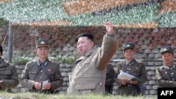 FILE - This picture taken Oct. 8, 2022, and released by North Korea's official Korean Central News Agency Oct. 10, 2022, shows North Korean leader Kim Jong Un, center, attending an air attack training exercise for the Korean People's Army Air Force at an undisclosed location.