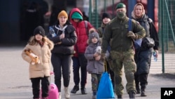 FILE - People fleeing from Ukraine cross the border in Vysne Nemecke, Slovakia, March 4, 2022. 