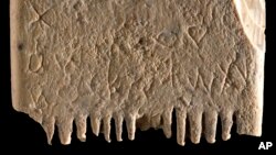 This undated image released by the Israel Antiquities Authority on Wednesday, Nov. 9, 2022, shows an ivory comb with an entire sentence in the Canaanite language. (Dafna Gazit, Israel Antiquities Authority via AP)