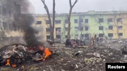A view shows cars and a building of a hospital destroyed by an aviation strike amid Russia's invasion of Ukraine, in Mariupol, Ukraine, in this handout picture released March 9, 2022 by the Press service of the National Police of Ukraine.