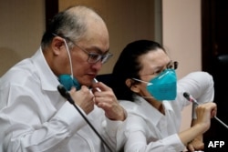 FILE - Lee Ming-che (L), a Taiwanese democracy activist who was jailed in China for five years, takes part in a press conference with his wife Lee Ching-yu (R) at the parliament in Taipei, May 10, 2022.