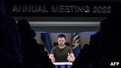 Ukrainia's President Volodymyr Zelensky appears on a giant screen during his address by video conference as part of the World Economic Forum annual meeting in Davos on May 23, 2022. 