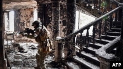 Ruski vojnik u bombardovanoj zgradi pozorišta u Marijupolju, 12. april 2022.