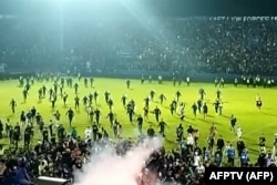 Tangkapan layar video AFPTV yang diambil pada 1 Oktober 2022 menunjukkan gas air mata yang disemprotkan di kerumunan saat suporter berlarian di lapangan setelah pertandingan sepak bola antara Arema FC dan Persebaya Surabaya di Stadion Kanjuruhan di Malang