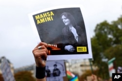 Seorang pengunjuk rasa menunjukkan potret Mahsa Amini saat demonstrasi untuk menentang kematiannya dalam tahanan polisi, Minggu, 2 Oktober 2022. (Foto: AP)