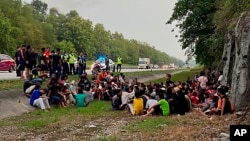 In this photo released by the Malaysia Royal Police, police detain Rohingya refugees who had escaped from the Sungai Bakap Temporary Immigration Depot, Penang, Malaysia, Wednesday, April 20, 2022. (Malaysia Royal Police via AP)
