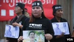 រូបឯកសារ៖ ស្ត្រី​សហគមន៏​បឹង​កក់​មួយ​ក្រុមកាន់​រូបថត​មន្រ្តី​សិទ្ធិ​មនុស្ស ​ដែល​ជាប់​ពន្ធនាគា​រ​ក្នុង​យុទ្ធនាការ​«​ថ្ងៃ​ច័ន្ទ​ពណ៌ខ្មៅ»​​នៅ​សហគមន៏​បឹងកក់​ ​រាជធានី​ភ្នំពេញ​ ​កាលពី​ថ្ងៃ​ច័ន្ទ​ ទី​២៣​ ខែឧសភា​នេះ​​ ដើម្បីទាមទារ​ឲ្យមាន​ការដោះលែងមន្រ្តី​សិទ្ធិមនុស្ស​៤រូប និង​មន្រ្តីគ.ជ.ប​​មួយរូប ​ដែល​ជាប់​ពន្ធនាគារ​កាលពី​ដើម​ខែ​ឧសភា​នេះ។ ​(ឡេង ឡែន/VOA)