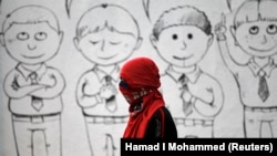 Seorang berdiri di depan mural siswa sekolah di dinding sekolah menengah untuk menentang hukuman mati otoritas Saudi. (Photo: REUTERS/Hamad I Mohammed)