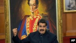 Venezuelan President Nicolas Maduro, shown at the presidential palace in Caracas with a painting of independence hero Simon Bolivar, defends gubernatorial election results at a news conference Oct. 17, 2017.