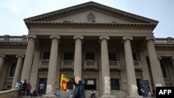 A demonstrator carrying a Sri Lankan national flag gestures in front of the presidential secretariat in Colombo on July 21, 2022.