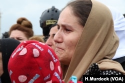 Women and men cry as they watch the U.N. team begin their search for the remains of thousands of victims in Kocho, Iraq, March 15, 2019.