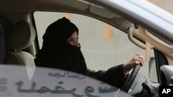 FILE - Aziza al-Yousef drives a car on a highway in Riyadh, Saudi Arabia, as part of a campaign to defy Saudi Arabia's ban on women driving, March 29, 2014. Saudi authorities have detained at least six activists, including three of the country's most prominent women's rights campaigners, just weeks before the kingdom is set to lift a ban on women driving, people familiar with the arrests said Friday, May 18, 2018.