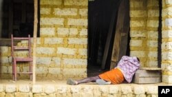 FILE - AA man suffering from the Ebola virus lies on the floor outside a house in Port Loko Community, on the outskirts of Freetown, in Sierra Leone. 