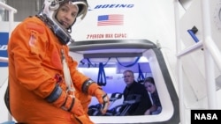 Astronaut Randy Bresnik prepares to enter Boeing CST-100 spacecraft for a fit check evaluation at the company's Houston Product Support Center. On Tuesday, Sept. 16, 2014 (NASA)