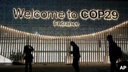 People walk outside the venue for the COP29 U.N. Climate Summit, in Baku, Azerbaijan, Nov. 11, 2024. 
