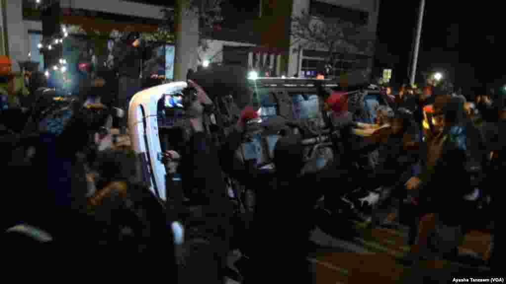 In a second night of violence following a grand jury's decision not to indict a white police officer in the shooting death of a black teenager, protesters attack and turn over a police car outside Ferguson City Hall, in Ferguson, Missouri, Nov. 25, 2014.