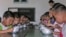 FILE - North Korean children eat lunch at a government-run kindergarten in Taedong county in south Pyongan province, July 18, 2005.