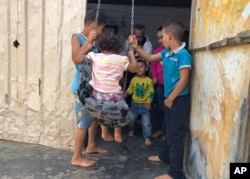 In this August 29, 2019 photo, Yousef Samara, a 42-year-old refugee from Syria’s Deraa province plays with his children and nephews inside his caravan, in the Zaatari camp in northern Jordan. (AP)