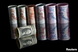 Uang kertas satu dolar AS terlihat di sebelah uang kertas lira Turki dalam ilustrasi yang diambil di Istanbul, Turki, 23 November 2021. (Foto: REUTERS/Murad Sezer)