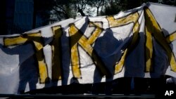 Israeli hard-line nationalist supporters of Israeli army medic Sergeant Elor Azaria hold a banner with his name outside the Israeli military court in Tel Aviv, Israel, Jan. 4, 2017.