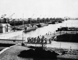 FILE - British troops march past undamaged port facilities in Antwerp, Nov. 15, 1944 before mounting guard over the dock area of the important Belgium port.